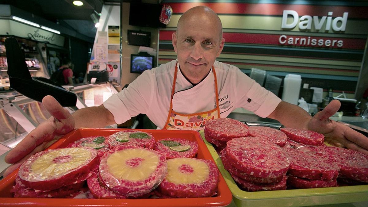 David Barroso, con dos bandejas de hamburguesas en su puesto del mercado de Santa Caterina