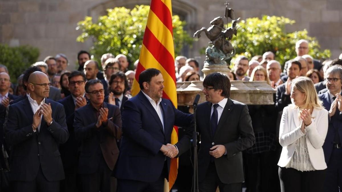 Oriol Junqueras y Carles Puigdemont se saludan en el acto solemne del Govern en apoyo al referéndum.