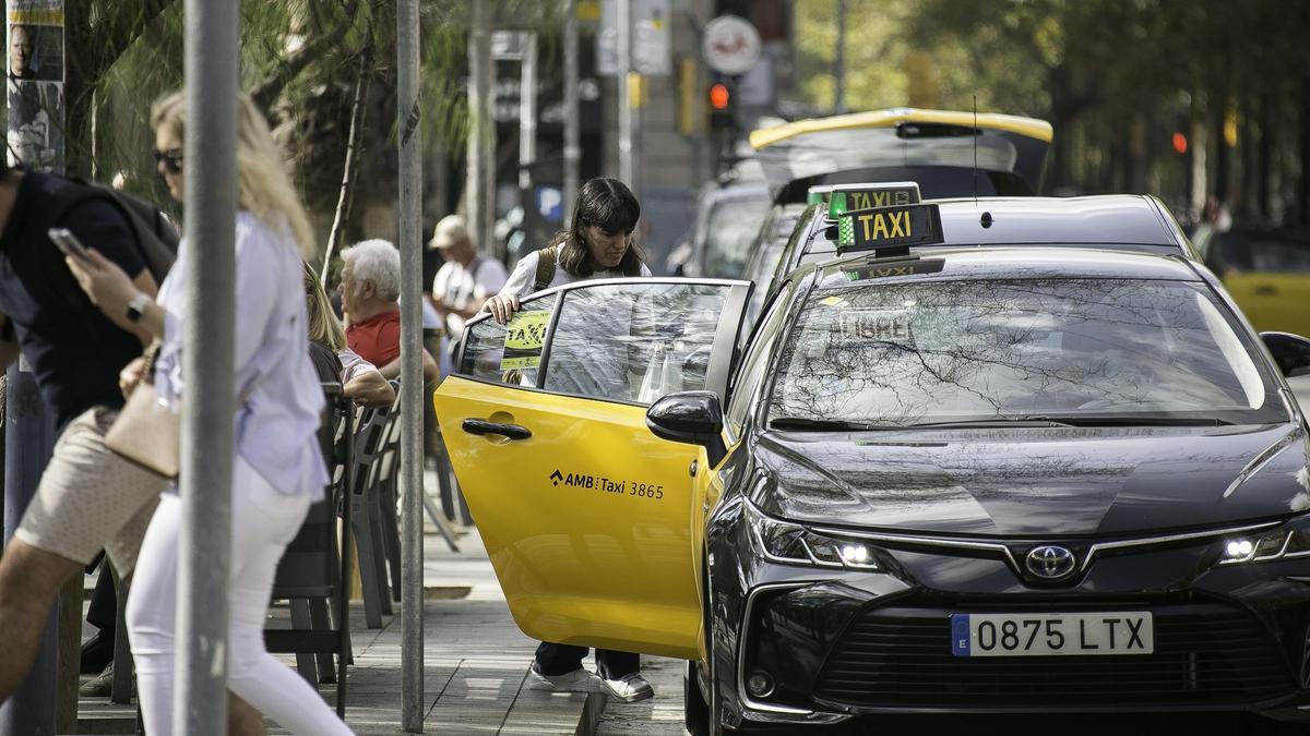 Una mujer sube a un taxi en la plaza de Universitat, en Barcelona.