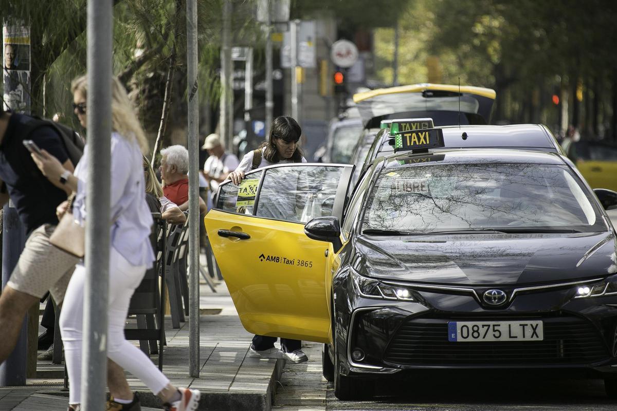 Una mujer sube a un taxi en la plaza de Universitat, en Barcelona.