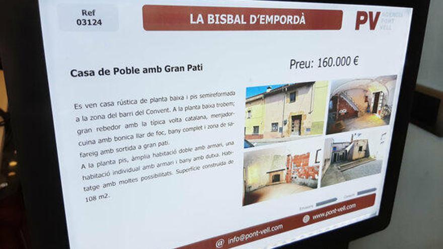 Primer pla d&#039;un cartell d&#039;una casa en venda en una immobiliària de la Bisbal d&#039;Empordà.