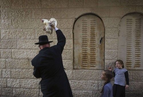 An ultra-Orthodox Jewish man holds a chicken as he performs the Kaparot ritual in Jerusalem ahead of Yom Kippur