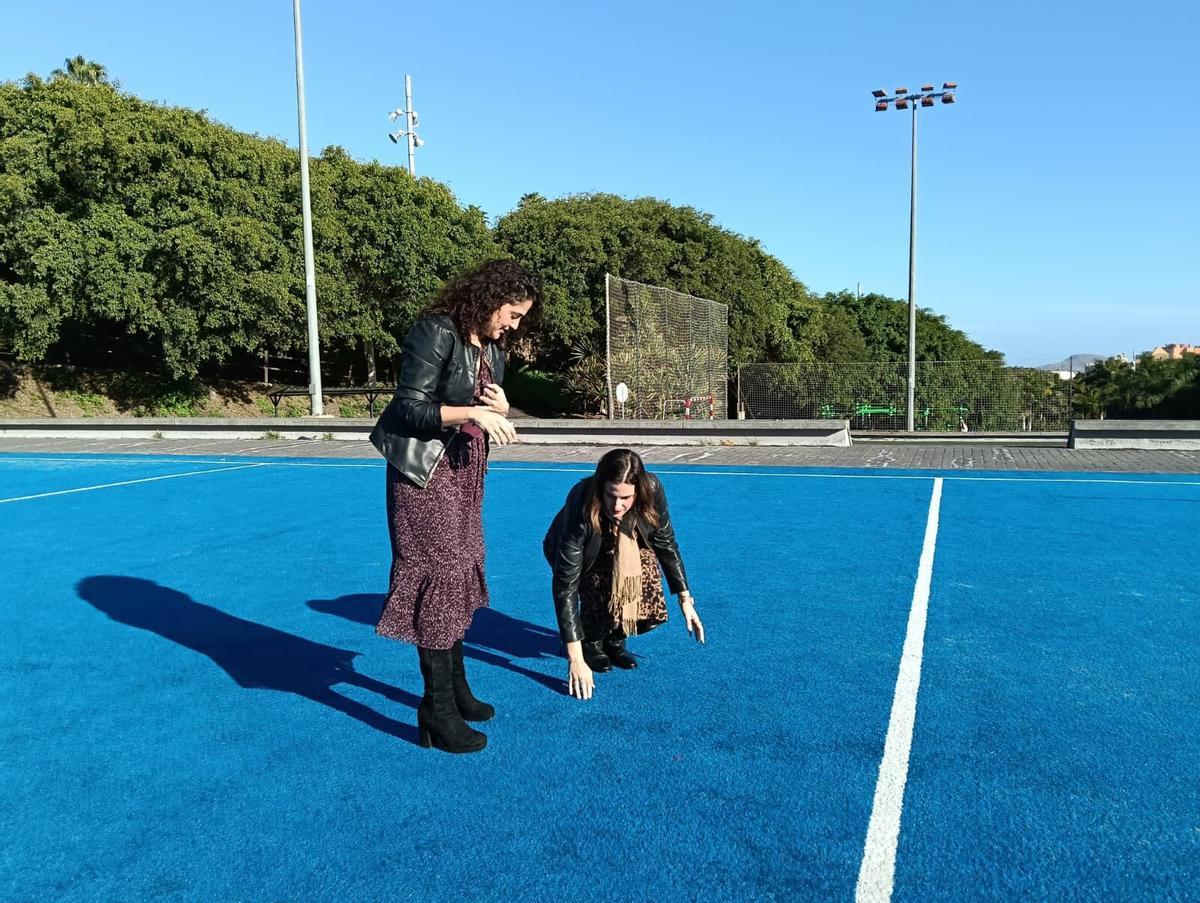Las concejalas Betsaida González y Carla Campoamor supervisan el césped del campo de fútbol de Juan Pablo II, en Siete Palmas.