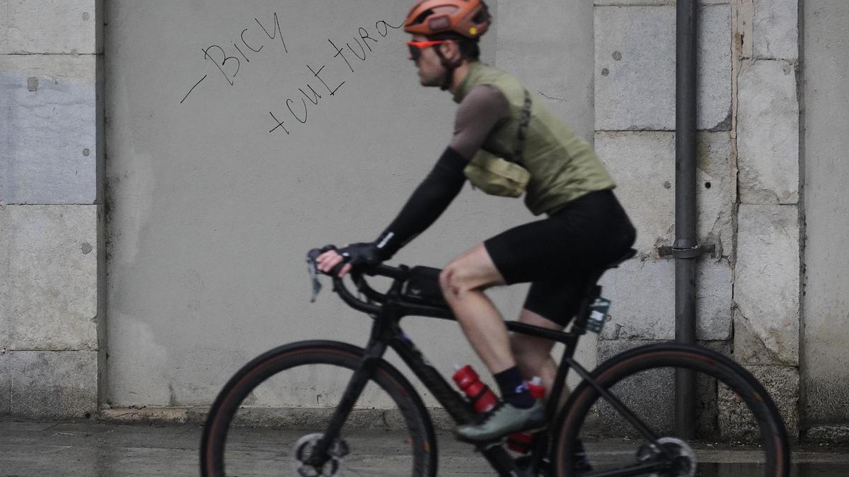 Un ciclista passa per una de les pintades que hauria fet el detingut a Girona.