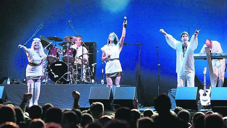 Los integrantes de «Abba Revival» saludan al público congregado en la playa de Poniente tras interpretar uno de los éxitos del legendario cuarteto sueco.  / juan plaza