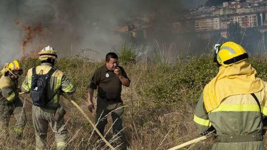 Brigadistas y un agente, en el incendio de A Farixa. // Brais Lorenzo