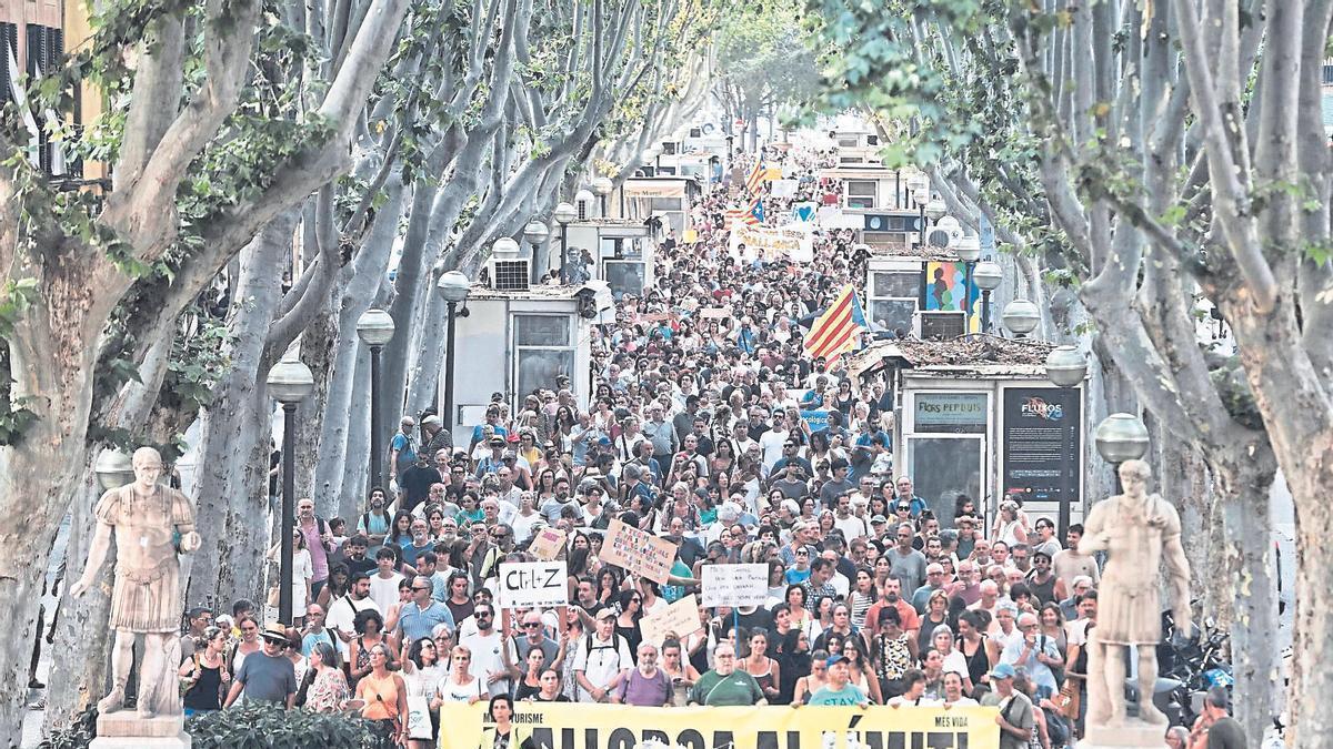 Manifestants contra la massificació turística al seu pas per la Rambla.