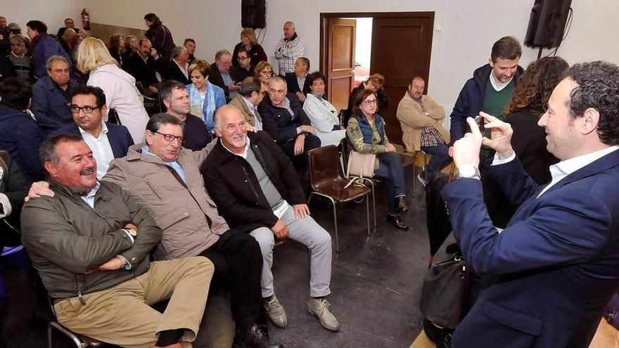 Guillermo Martínez, consejero asturiano de Presidencia, saca una foto a los asistentes al acto de Pola de Lena.