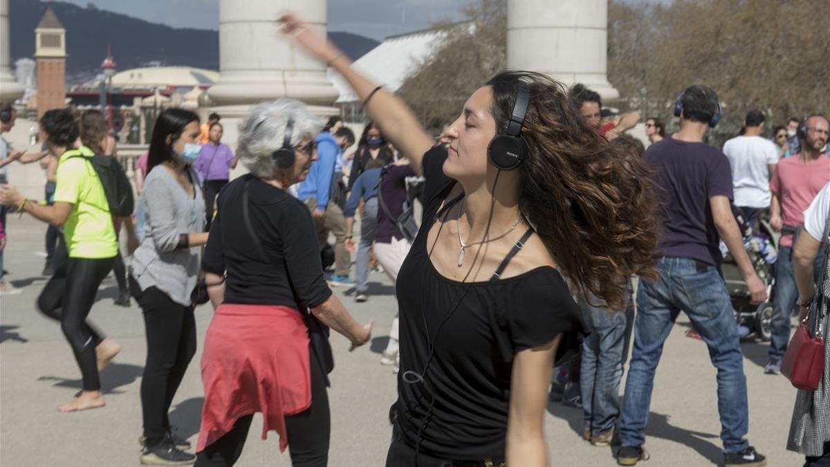 Barcelona 14 03 2021   Barcelona  Barceloneando per Ana Sanchez  Un grupo multitudinario se reune en la font magica de Montjuich para la practica del  silent disco  donde la gente baila escuchando musica a traves de los cascos  Fotografia de Jordi Cotrina