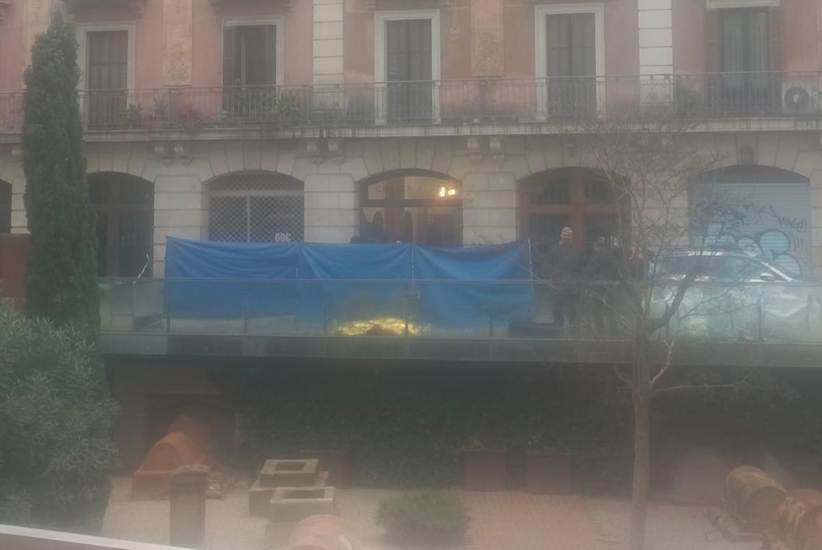 El cadáver tendido y cubierto con una lona, durante las pesquisas de los Mossos d'Esquadra, en la plaza Vila de Madrid, en el barrio Gòtic de Barcelona.