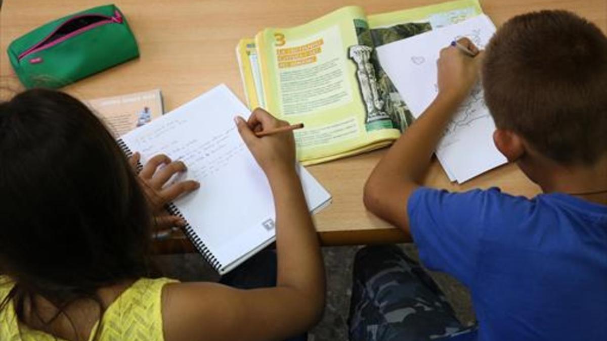 Dos niños hacen deberes después del colegio.