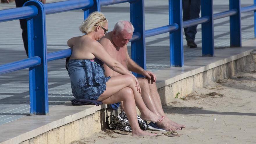 Dos turistas ayer martes en la playa del Postiguet