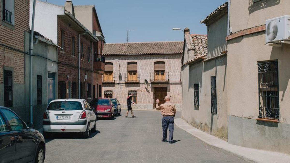 Dos vecinos de Los Cerralbos, en Toledo, se saludan por la calle.al