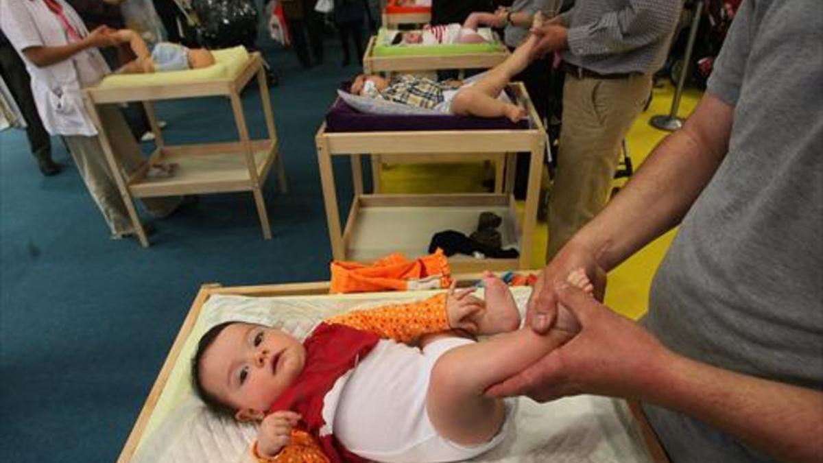 Varios padres, con sus hijos, en una jornada de la feria Mamás-Bebés, en Cornellà.