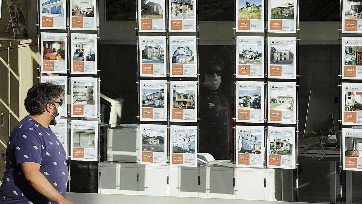 Un hombre revisando las ofertas de venta de pisos en una inmoiliaria
