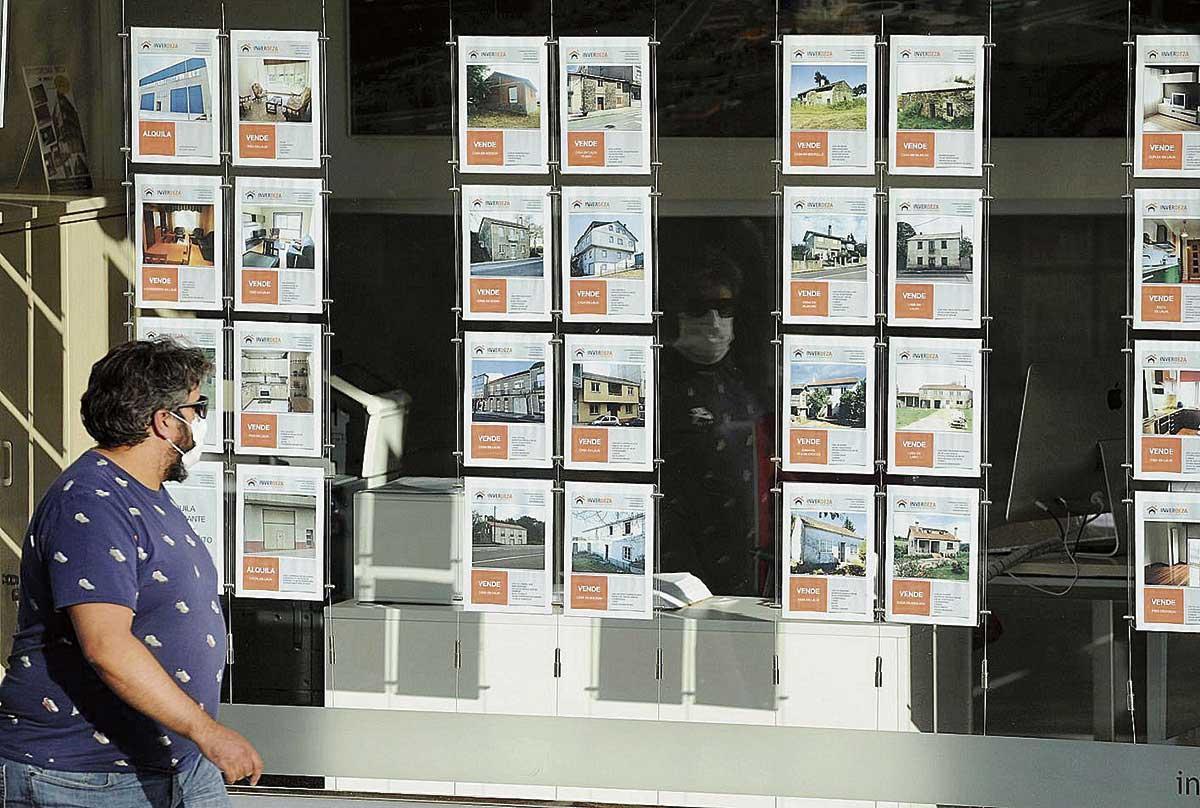Un hombre revisando las ofertas de venta de pisos en una inmoiliaria