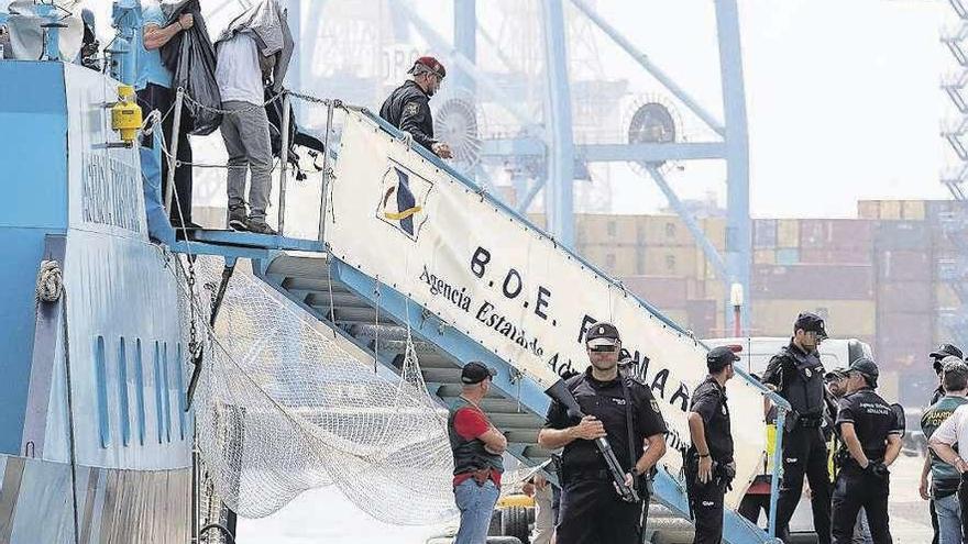 Uno de los cuatro tripulantes detenidos baja la escalinata del remolcador.