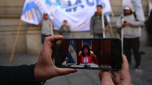 Un simpatizante de Cristina Fernández de Kirchner sigue su alegato en el juicio, este viernes en Buenos Aires.