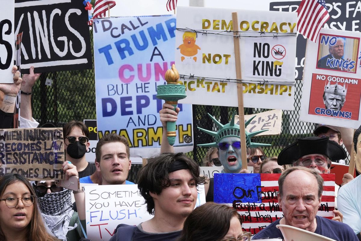 Demonstrators carrying signs stand near the White House during a protest taking place on the day of a military parade commemorating the Armys 250th anniversary, coinciding with President Donald Trumps 79th birthday, Saturday, June 14, 2025, in Washington. (AP Photo/Alex Brandon)