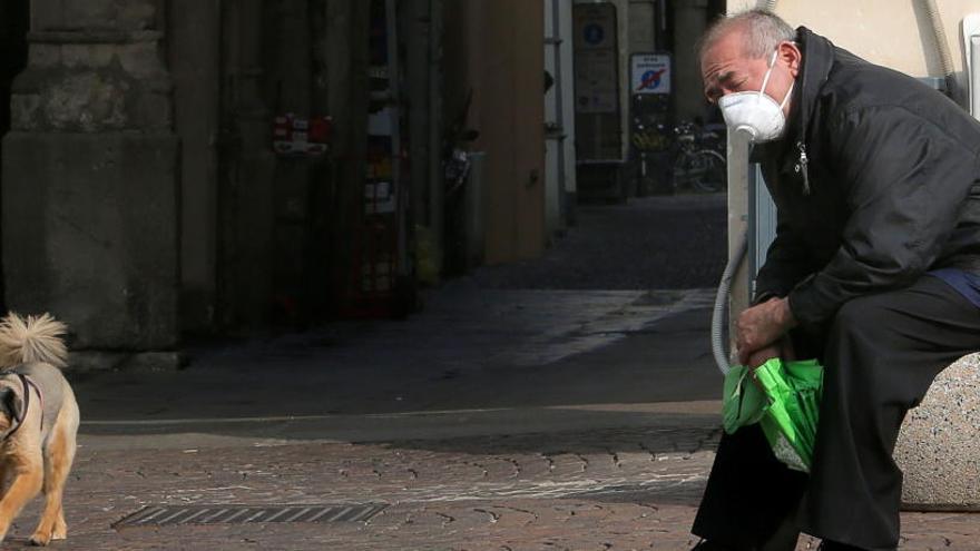 Un hombre con mascarilla pasea a su perro.