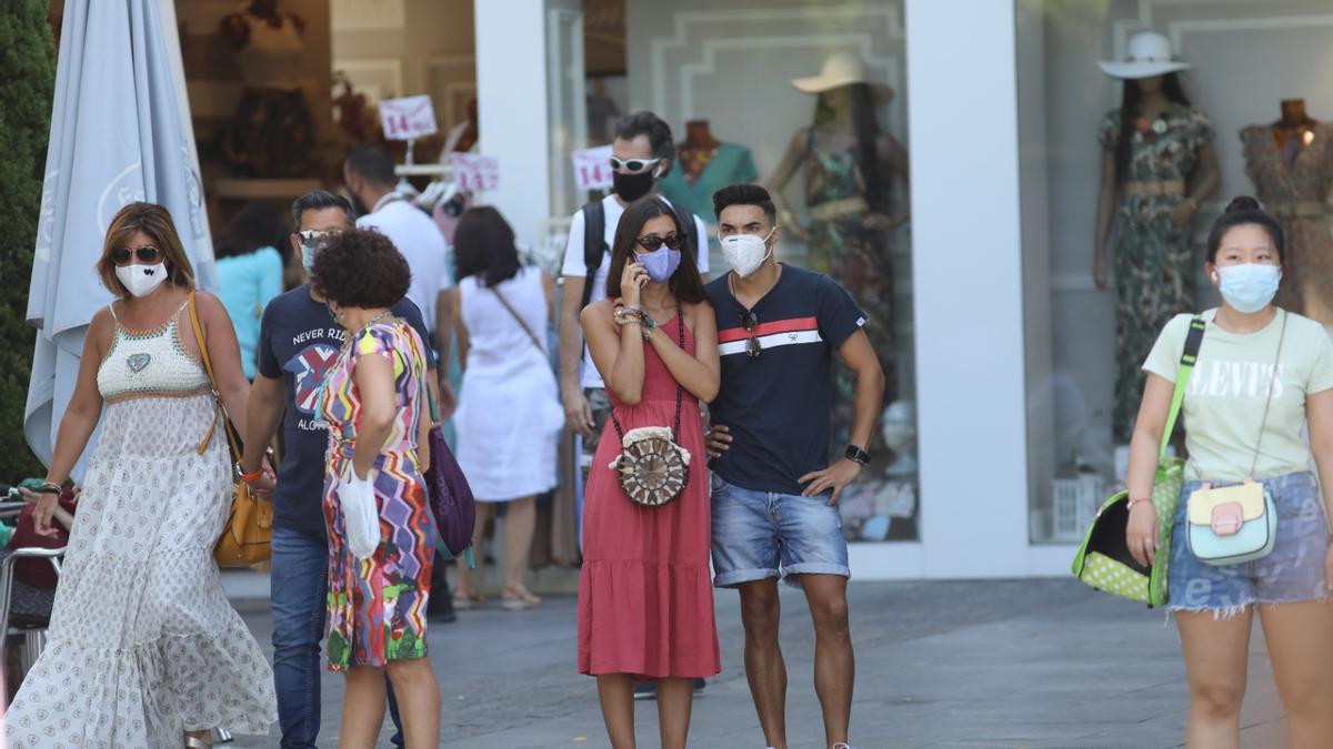 Una calle de Córdoba con la mayoría de viandantes con mascarilla.