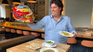 Adrián Vallés, con uno de sus cascos de competición y varios de los platillos que ofrece en Bar Monrys.
