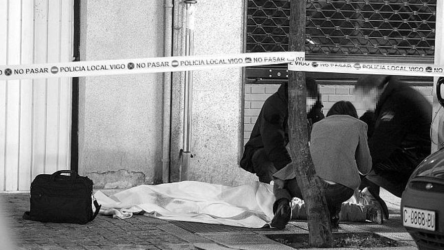 Agentes de la Policía Nacional, junto al cadáver del joven en la calle Torrecedeira.