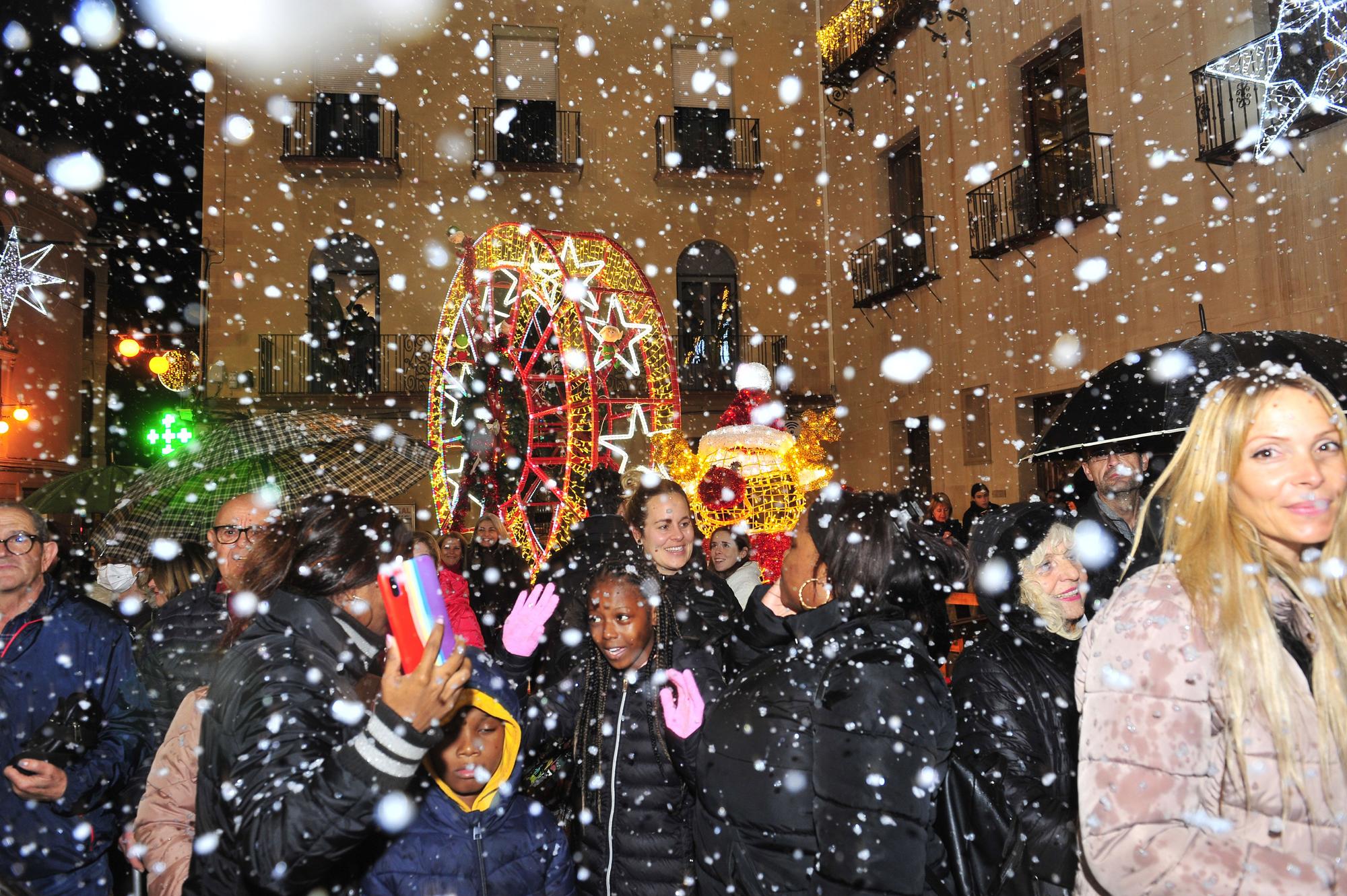 Elche enciende la Navidad con una gran "nevada" y... lluvia intermitente