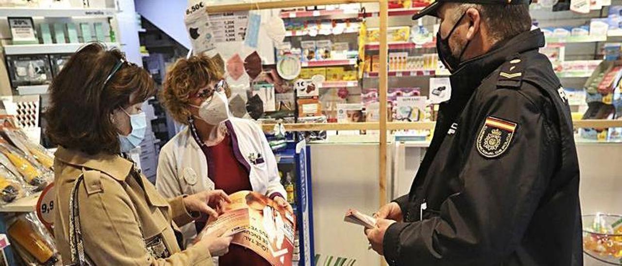 Alberto Vior y María del Carmen Ovies, ayer, informando de la campaña a la farmacéutica de Llaranes, Pilar Fernández.