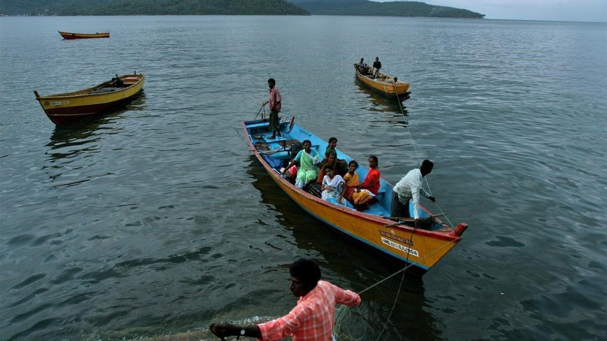 Pescadores y mujeres vuelven a sus casas en Port Blair, en el archipiélago de las Andamán, al que pertenece la isla Strait Island, donde vive la tribu Gran Andameneses.