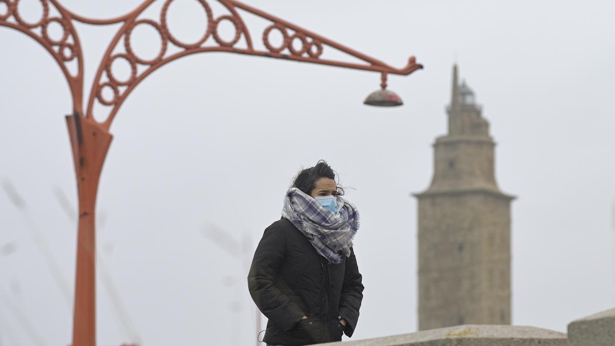 Archivo - Una persona camina protegida del frío en el Paseo Marítimo de A Coruña.