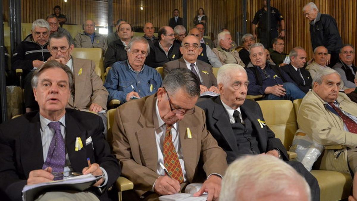 Los exmilitares acusados por crímenes de lesa humanidad Luciano Benjamín Menéndez (tercero por la izquierda) y Gustavo Alsina (segundo por la izquierda), con la escarapela en la solapa, el jueves en un tribunal de Córdoba (Argentina).