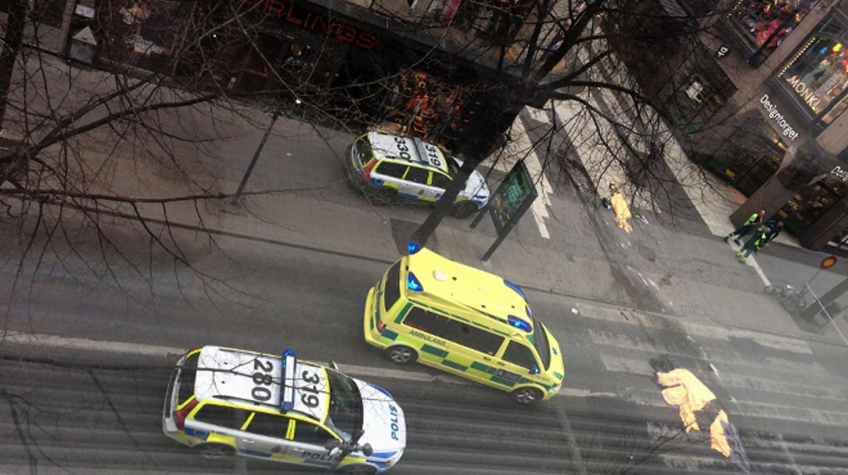 Una ambulància davant els cossos de les tres víctimes mortals en un atemptat amb camió a Estocolm.