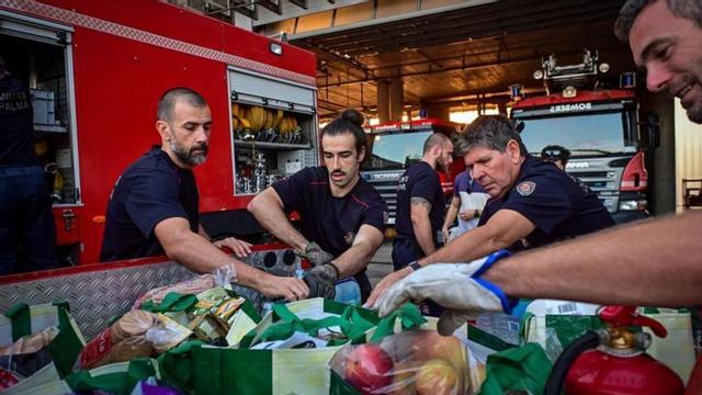 Los bomberos de Palma cargando los camiones con suministros.