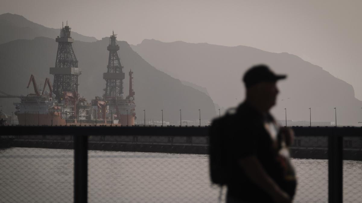 Un hombre pasea por el puerto de Santa Cruz durante una jornada con calima.