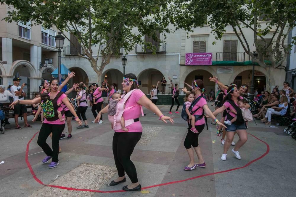 Un grupo de madres representa la canción central del musical «Mamma Mia» en la plaza de El Raval porteando a sus bebés