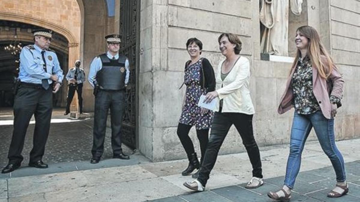 Laia Ortiz, Ada Colau y Janet Sanz se dirigen al punto en el que la segunda habló ayer ante los medios, en la plaza de Sant Jaume de Barcelona.