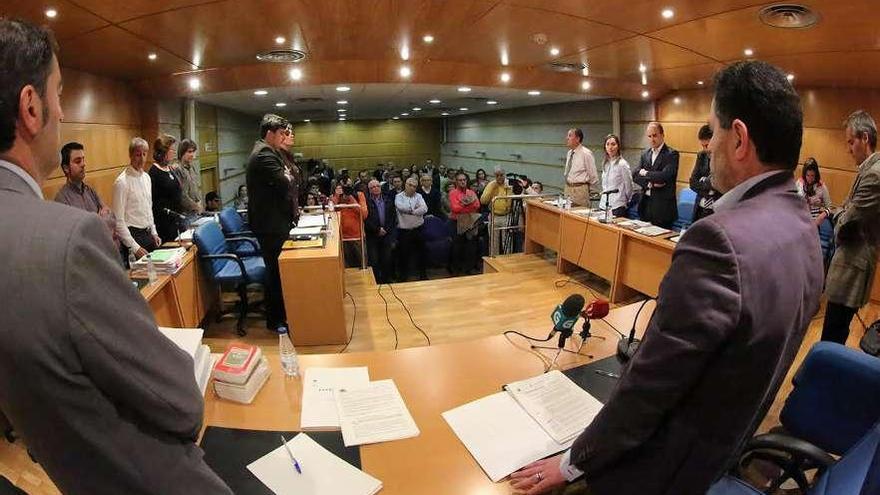 Miembros de la corporación municipal y vecinos guardan un minuto de silencio por el padre del regidor.  // A.H.