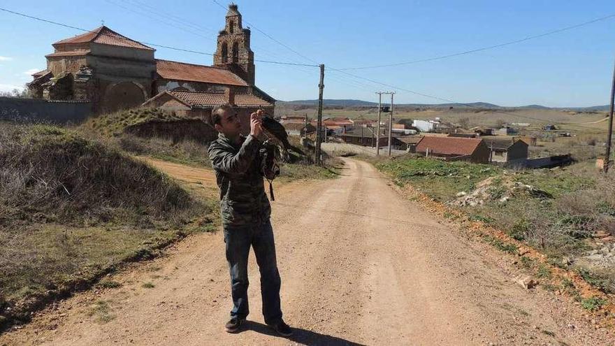 Un hombre con una rapaz. Al fondo, iglesia de La Torre del Valle.