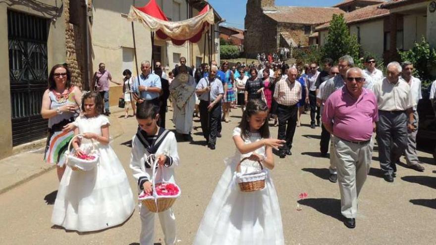 Los niños que este año han hecho la primera comunión tiran pétalos de flores para que pase la custodia.