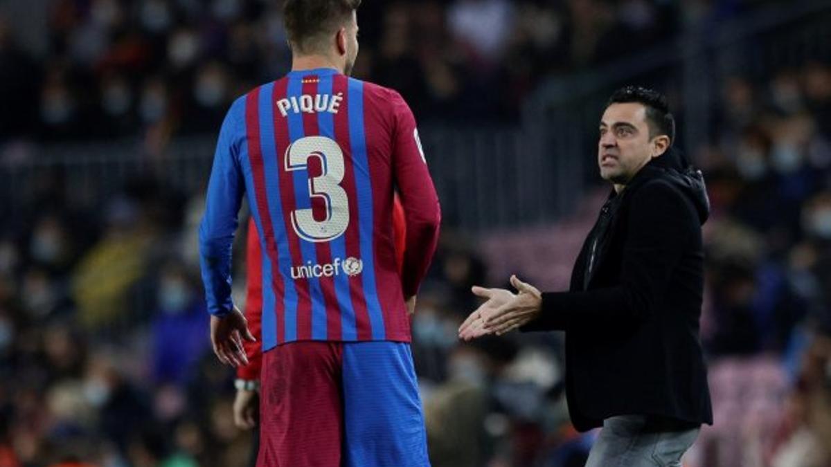 Gerard Piqué y Xavi Hernández hablando durante un partido del Barça