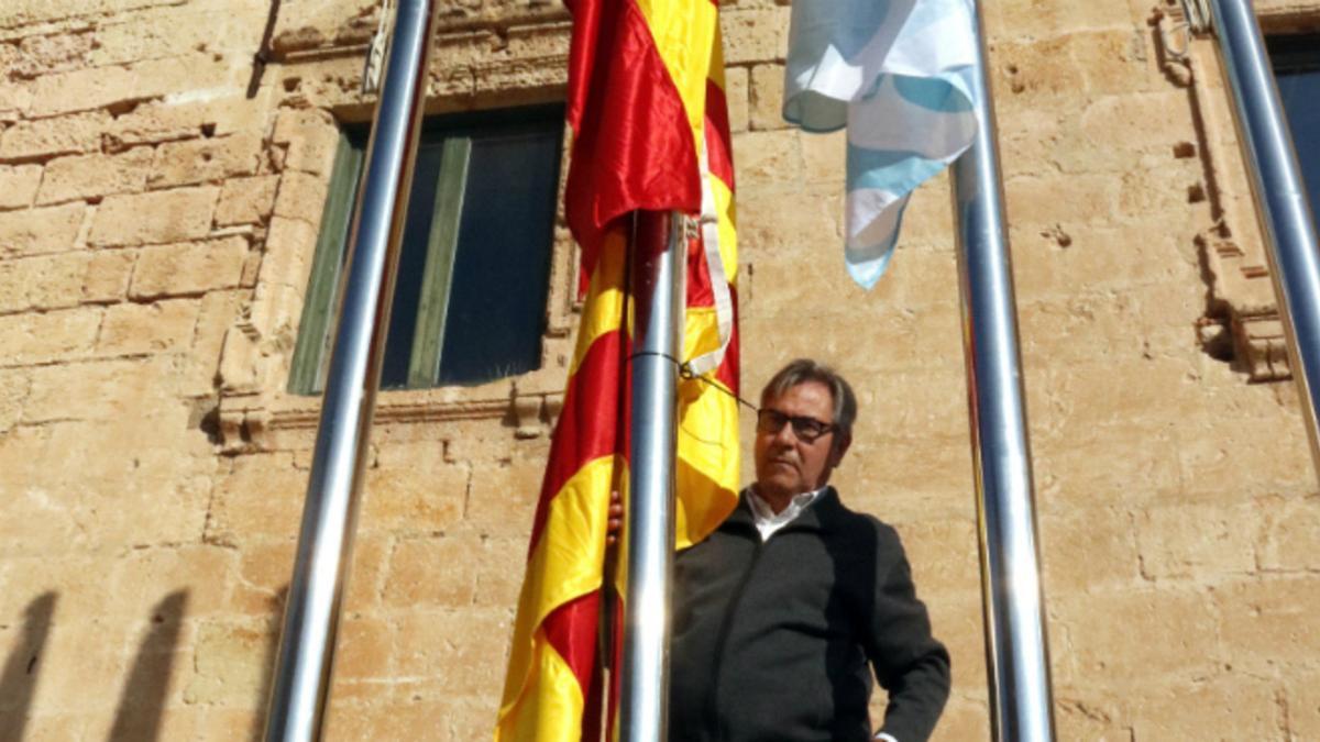 El alcalde de Torredembarra, Eduard Rovira, junto al mástil en el que puso la bandera española y, debajo, la 'senyera'.