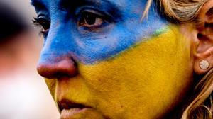 Una mujer tiene la cara pintada con los colores nacionales de Ucrania durante una protesta llamada Alto a la guerra. Paz para Ucrania y toda Europa en Berlín, Alemania, el 27 de febrero de 2022.