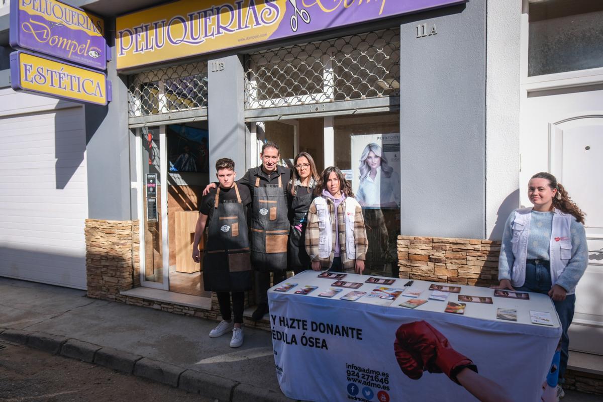 Los impulsores de esta iniciativa junto a las voluntarias de Admo a las puertas de la peluquería, en la barriada de Llera.