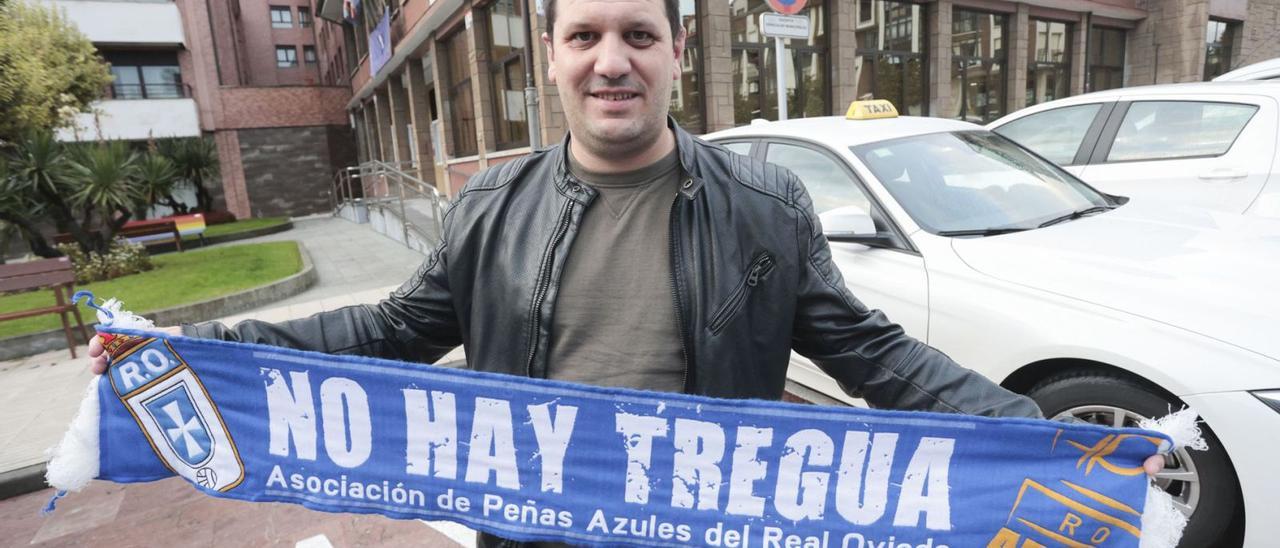 Javier Pérez, en la parada de taxis ubicada frente al Ayuntamiento de Llanera, con una bufanda del Oviedo. | Irma Collín