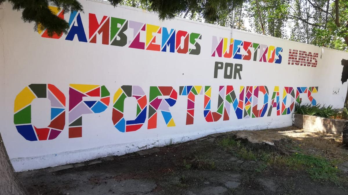 Mural colaborativo con el lema &#039;Cambiemos nuestros muros por oportunidades&#039; pintado por el alumnado del IES María Moliner..