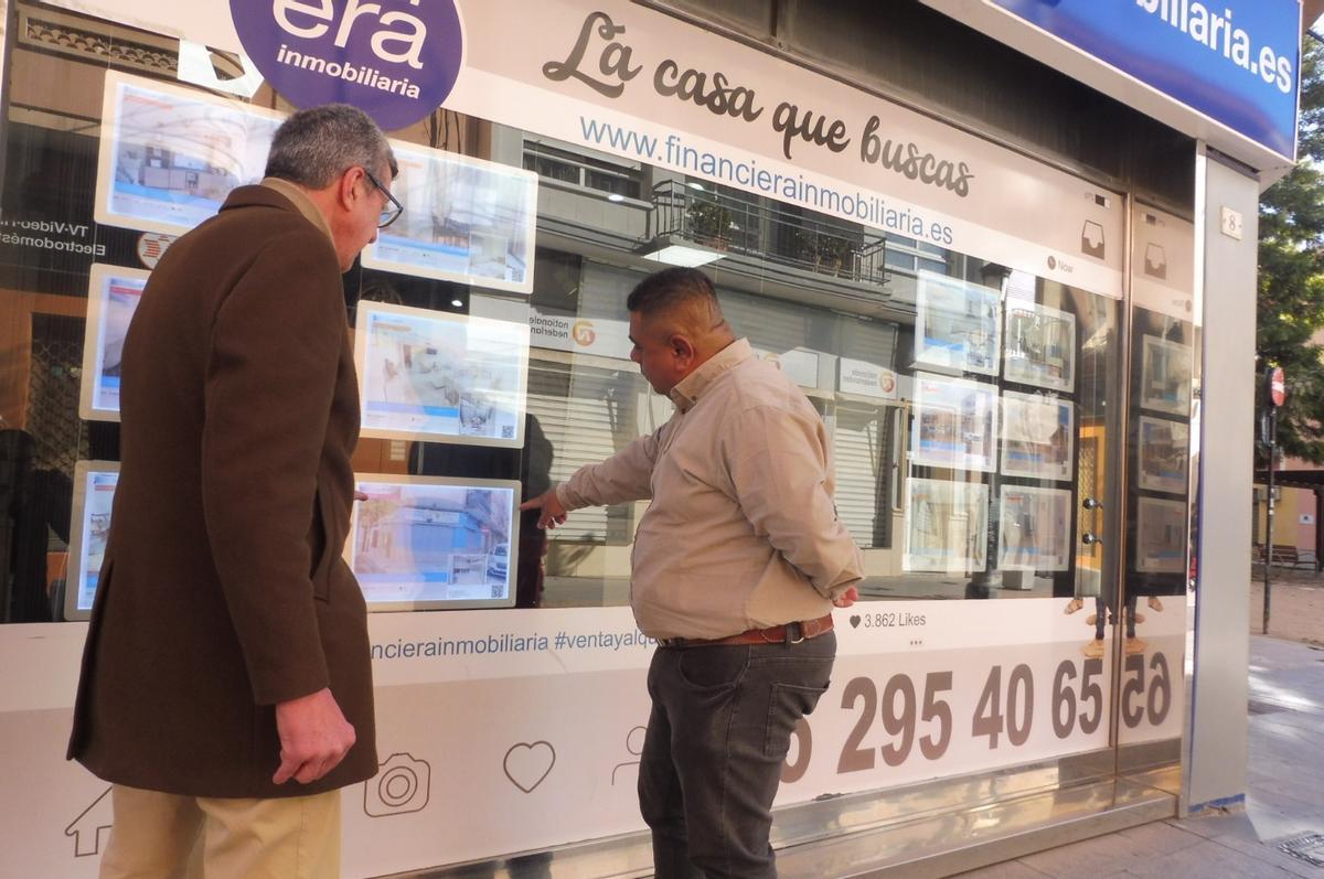Dos hombres observan las ofertas en una inmobiliaria de Gandia, en una imagen de archivo.