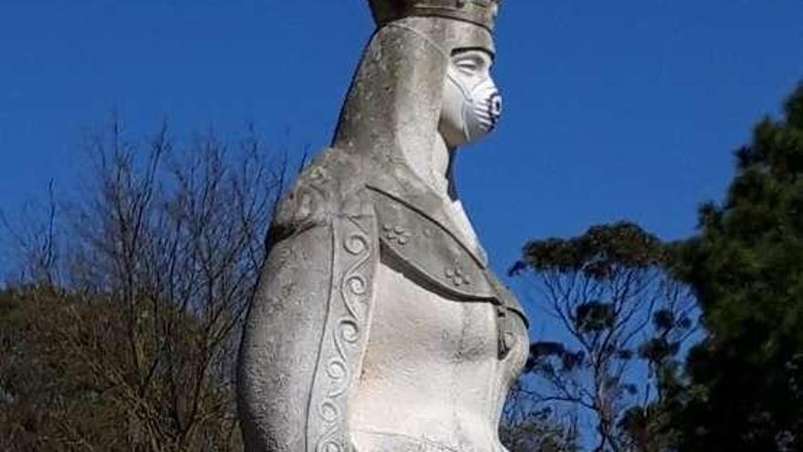 Escultura de Isabel la Católica con una mascarilla por la contaminación.
