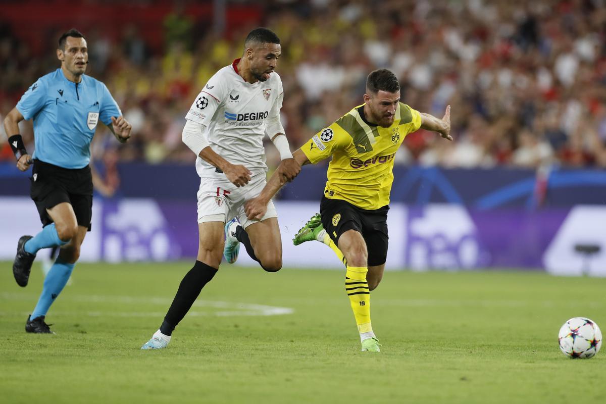 SEVILLA. 05/10/2022. - En-Nesyri (c), del Sevilla, lucha por el balón con Salih Özcan (d), del Borussia Dortmund durante el partido de Liga de Campeones disputado hoy en el estadio Sánchez Pizjuan de Sevilla. EFE/José Manuel Vidal