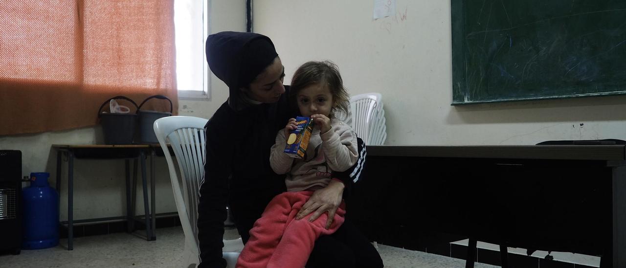 Farah con una de sus hijas, en un aula de la escuela donde se encuentran refugiadas.